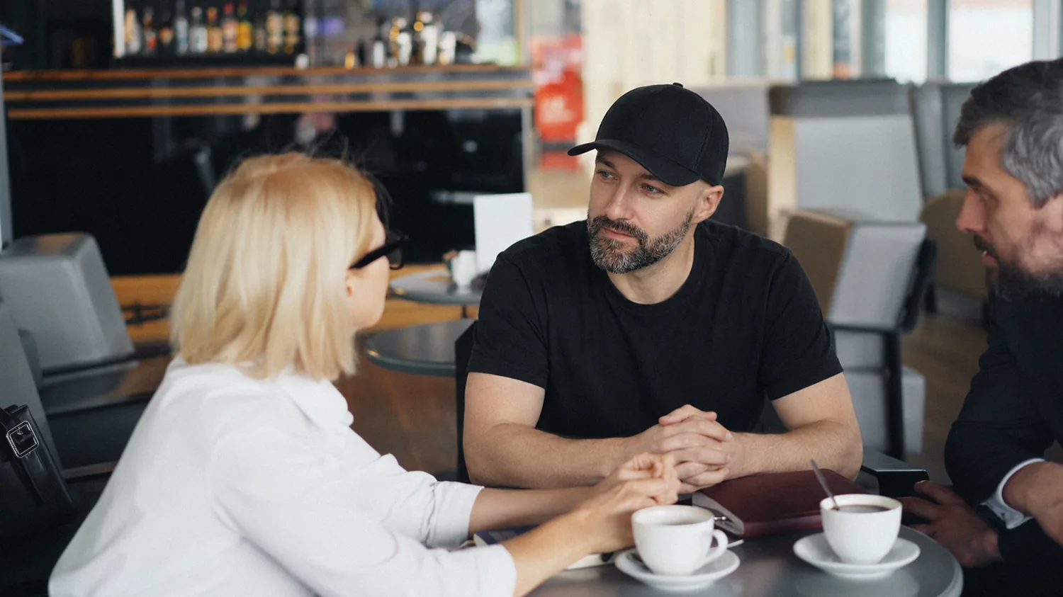 Ryan Stanikk at a cafe table, listening across two coffees